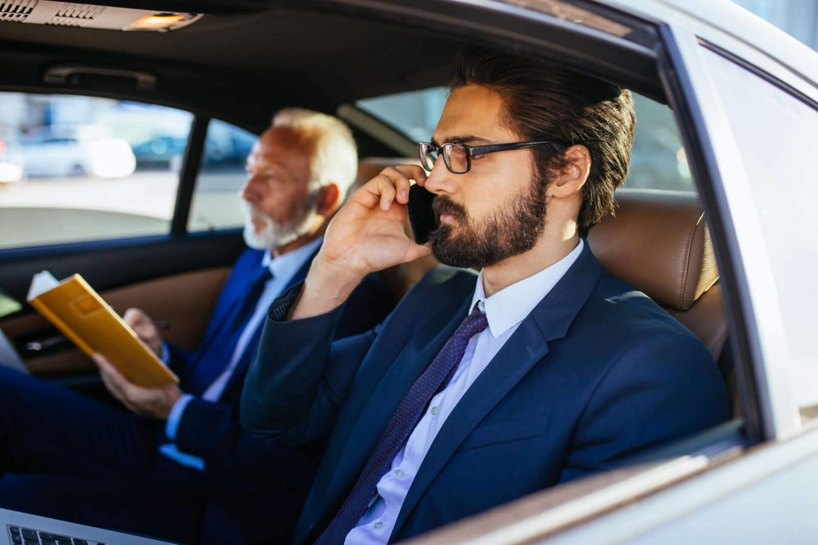 Businessmen riding in a private car with American Car Service New Jersey for a comfortable corporate trip.
