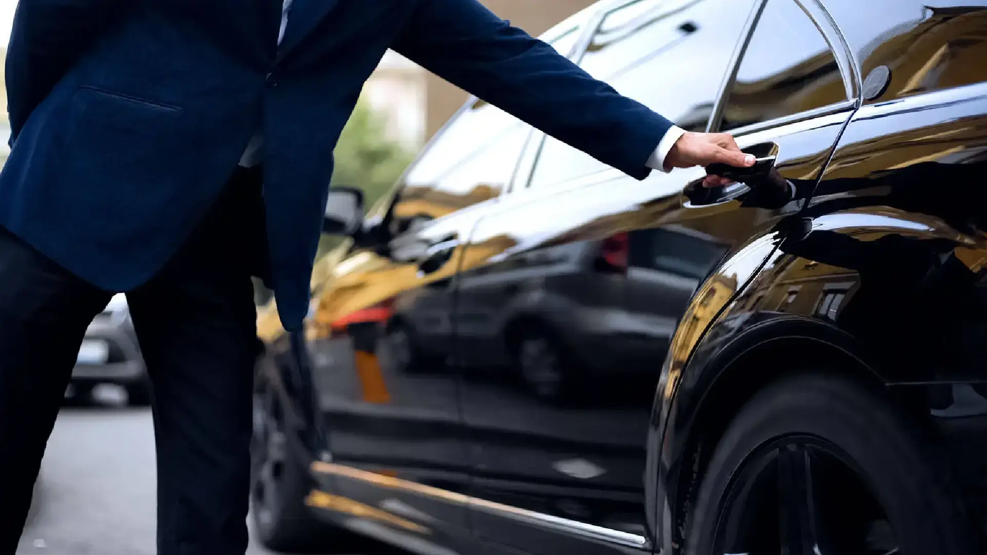 Professional chauffeur opening a luxury car door for American Car Service in New Jersey.